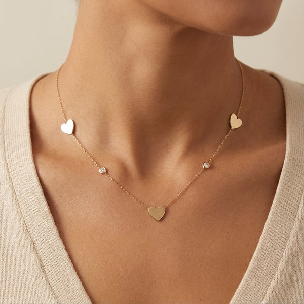 14Kt gold necklace with three heart charms and two bezel-set diamonds photography by Morelove Designs