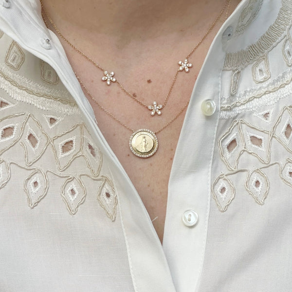 Reversible gold pendant necklace featuring Virgin Mary and M symbol, with ruby accents on back.