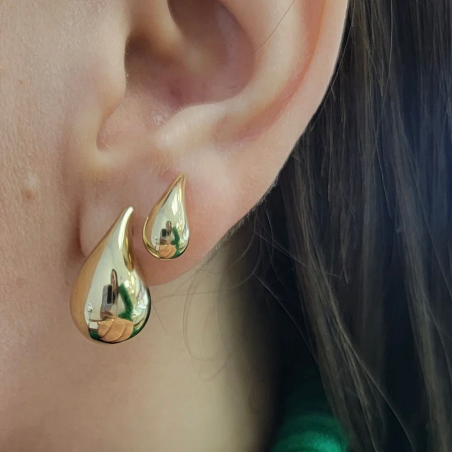 Adult model wearing elegant 14Kt gold drop earrings, quiet luxury aesthetic