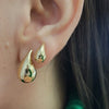Adult model wearing elegant 14Kt gold drop earrings, quiet luxury aesthetic