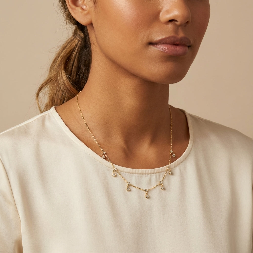 Dainty golden plated silver necklace featuring multiple bezel-set cubic zirconia double dangles, perfect for layering.