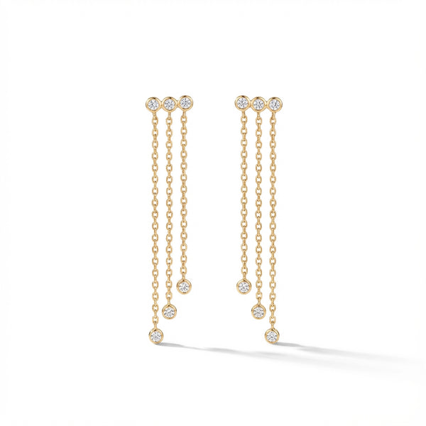 Elegant 14Kt gold diamond fringe earrings, featuring three delicate chains with diamond drops on a woman's earlobe.
