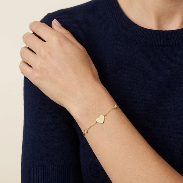 14Kt gold bracelet with three heart charms and two bezel-set diamonds, dainty luxury jewelry for women. photography by Morelove Designs