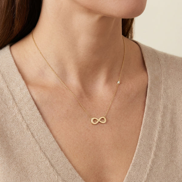 14kt gold infinity necklace with a delicate side bezel diamond, elegant fine jewelry for women photography by Morelove Designs